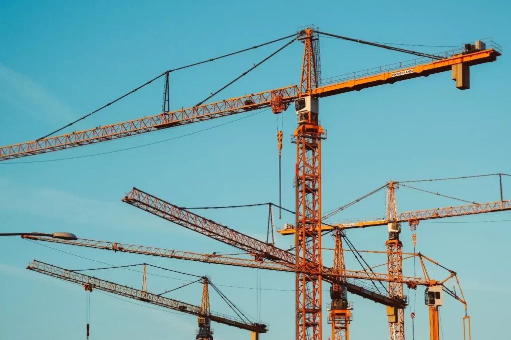Lifting Equipment exemplified among towering cranes against a blue sky