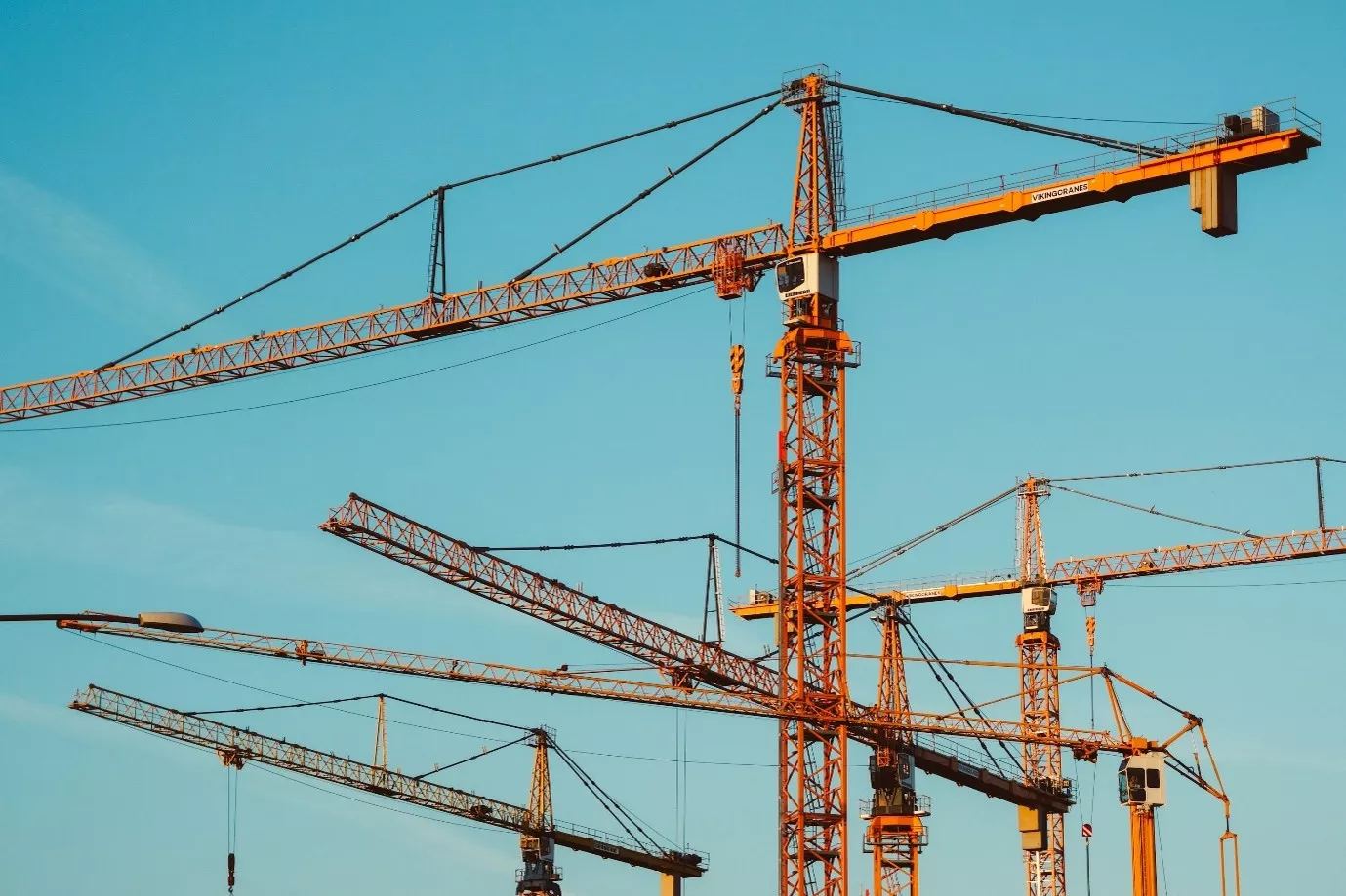 Lifting Equipment exemplified among towering cranes against a blue sky